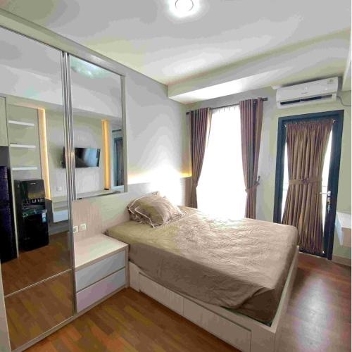 a bedroom with a bed and a large window at Kyra Property in Pegadungan