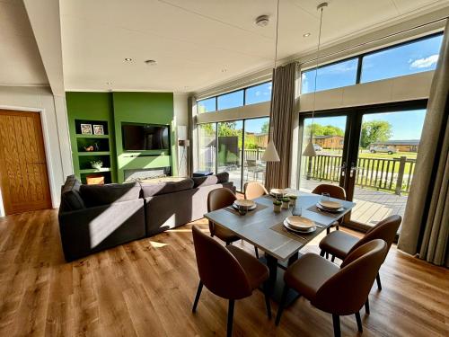 a living room with a couch and a table and chairs at Forest Hills Holidays in Coleford