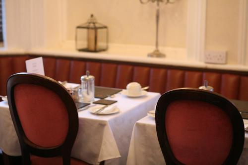 a table in a restaurant with two chairs and a table with a tableablish at Highlands Hotel and bar in Hastings