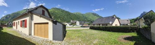 a group of houses with mountains in the background at Gîte Monplaisir in Gère-Belesten