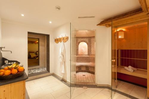 a bathroom with a shower with a glass shower stall at Hotel Augarten in Neustift im Stubaital