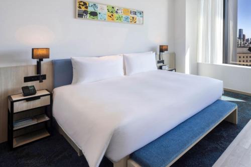 a bedroom with a large white bed and a window at Hyatt House Tokyo Shibuya in Tokyo