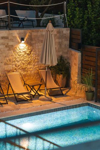 a swimming pool with two chairs and an umbrella at Casa Bianca & Spa in Ulcinj