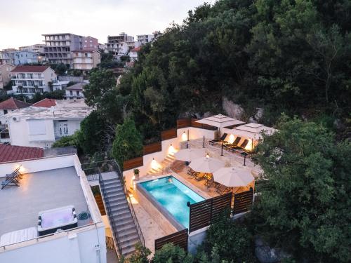 an aerial view of a house with a swimming pool and umbrellas at Casa Bianca & Spa in Ulcinj