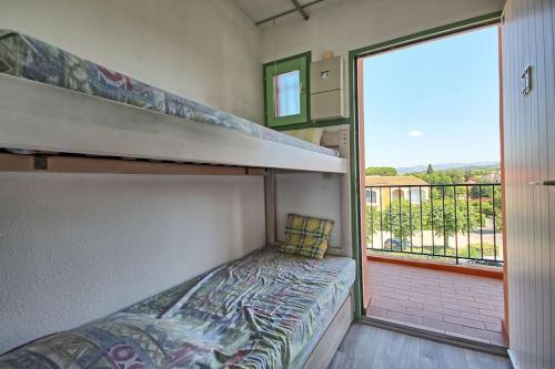 - une petite chambre avec des lits superposés et un balcon dans l'établissement Studio cabine, à La Londe-les-Maures