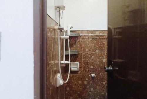 a bathroom with a mirror and a shower at RedDoorz at Rachael Pension House in Santander