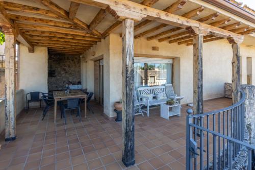 a patio with a wooden roof and a table at Casa Rural Cantueso 1 in La Matilla