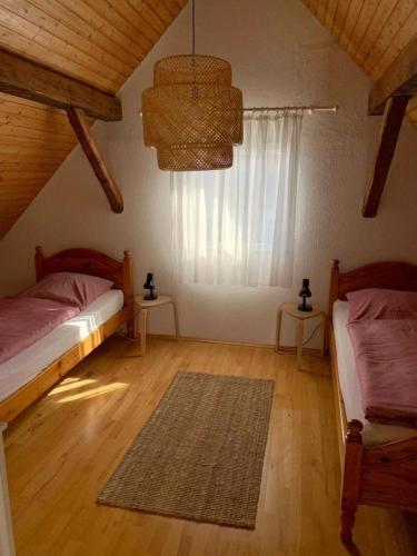 a bedroom with two twin beds and a window at Haus Alkmene in Bodman-Ludwigshafen