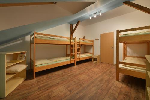a room with three bunk beds in a room at Hostel Hluboká in Hluboká nad Vltavou
