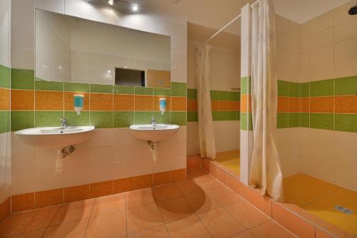 a bathroom with two sinks and a mirror at Hostel Hluboká in Hluboká nad Vltavou