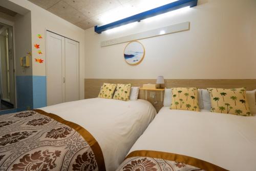 two beds sitting next to each other in a room at HOTEL AARON通天東 in Osaka