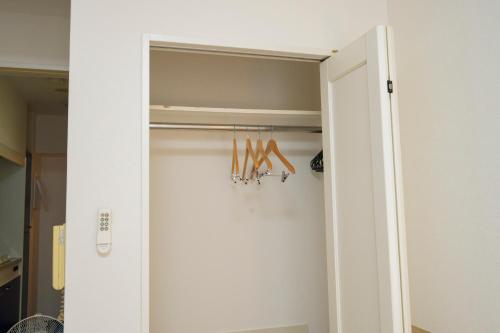 a door to a closet with a pair of scissors at HOTEL AARON通天東 in Osaka