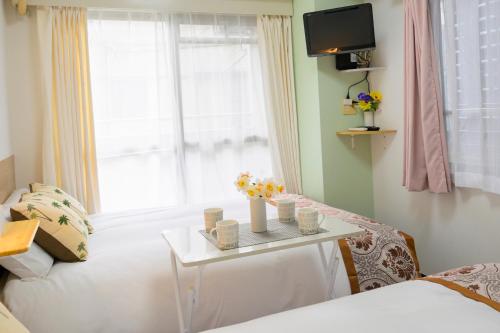 a room with a bed and a table with flowers on it at HOTEL AARON通天東 in Osaka