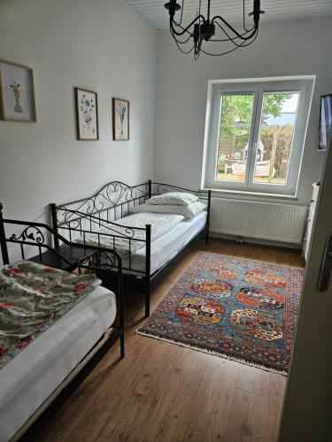 a bedroom with two beds and a rug and a window at Joes Cottage in Lackenbach