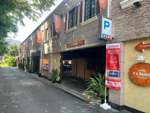 a building with a parking sign next to a street at T's Resort HAMAMATSU in Hamamatsu