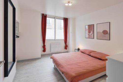 a bedroom with a bed and a window with red curtains at Centre-ville - Fibre - Netflix - T2 LE RIEFFEL in Nozay