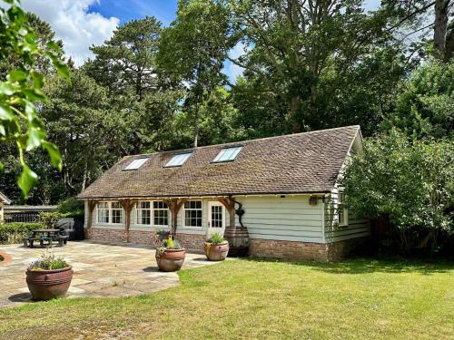 una casa con finestre e piante in un cortile di Lynford Holiday Cottages nestled in the heart of Thetford Forest a Mundford