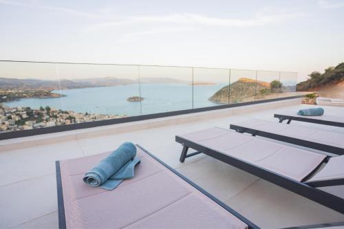 a room with tables and a view of the water at Panoramic Villa in Tolo