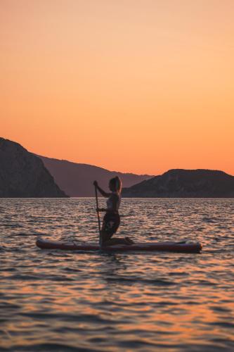 a person on a paddle board in the water at Marpunta Resort, Santikos Collection in Patitiri