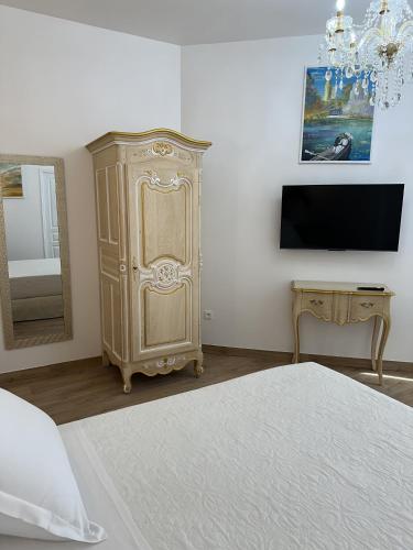 - une chambre avec un lit, une commode et une télévision dans l'établissement Studio Cosy du Cloitre, à Narbonne