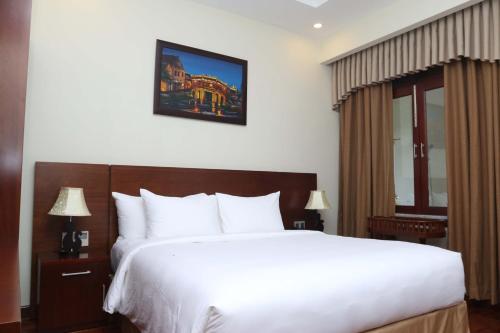 a bedroom with a large white bed and a window at Ebisu Onsen Resort in Ba Na