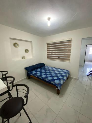 a bedroom with a bed and a table and a chair at Departamento vacacional in Mazatlán