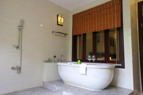 a bath tub in a bathroom with a window at Ebisu Onsen Resort in Ba Na