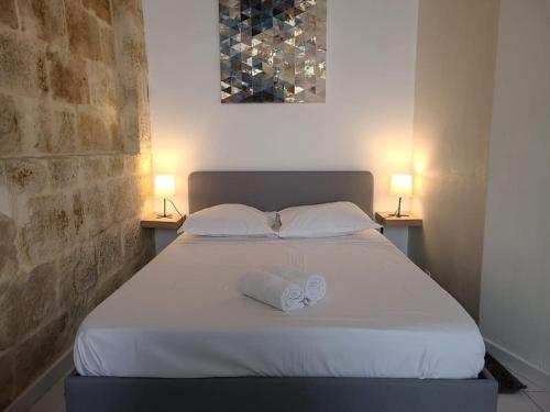 un lit blanc avec deux oreillers et deux lumières sur deux tables dans l'établissement Appartement Cosy et Calme - Centre historique, à Montpellier