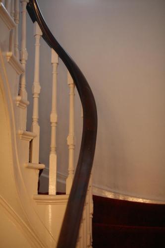 a spiral staircase with white railings and a stair case at Highlands Hotel and bar in Hastings