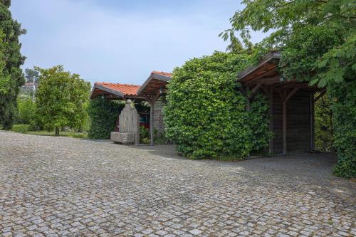 a house with a stone driveway next to a building at Authentic apartment in rural area in Pindo