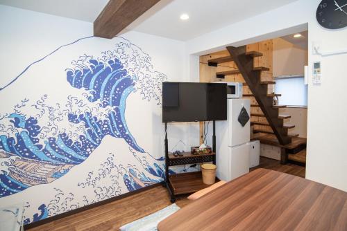 a living room with a mural of a wave on the wall at Traditional Japanese House, 100years, Renovated into Japanese art, Shinsekai in Osaka