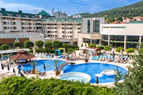 a hotel with a large swimming pool in a resort at A Hoteli - Hotel Izvor in Arandelovac
