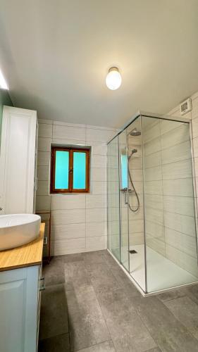 a bathroom with a glass shower and a sink at Juaniz in Tolmin