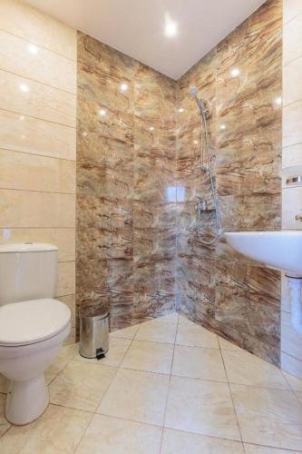 a bathroom with a toilet and a sink at Хотел Черноморец in Chernomorets