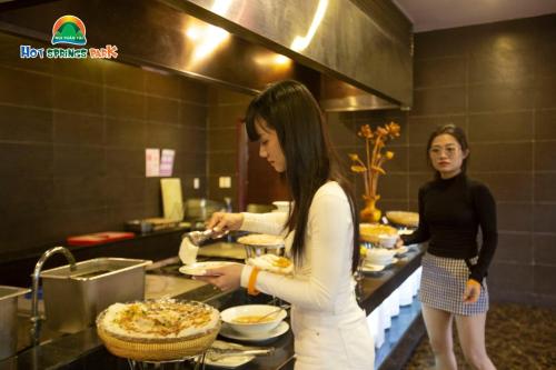 two women standing in a kitchen preparing food at Ebisu Onsen Resort in Ba Na