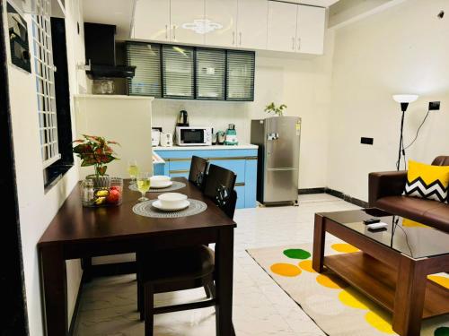 a kitchen and living room with a wooden table and a kitchen at BluO Penthouse Gachibowli - Terrace Garden in Hyderabad