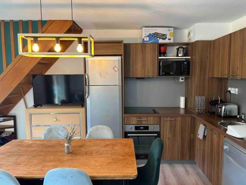 une cuisine avec une table, des chaises et un réfrigérateur dans l'établissement 3P en Duplex à Isola 2000, 6-8 personnes, à Isola 2000
