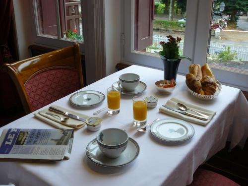a table with food and drinks and bread on it at La Villa Bois Joli HOTEL RESTAURANT in Bagnoles de l'Orne