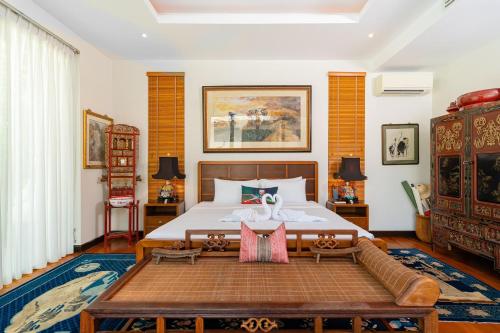 バンタオビーチにあるBaan Mandala Villa 4の大きなベッドとソファのある寝室