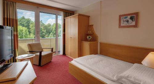 a hotel room with a bed and a window at Hotel Stoiser in Loipersdorf bei Fürstenfeld