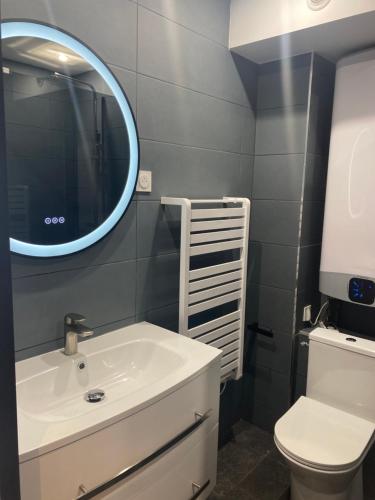 une salle de bain avec un lavabo blanc et un miroir dans l'établissement Au Petit Thalassa, à Boulogne-sur-Mer