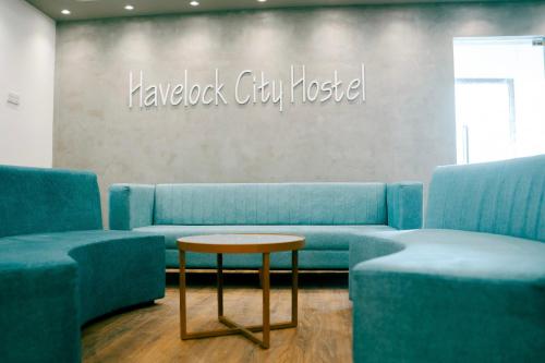 a living room with blue couches and a table at Havelock City Hostel, Colombo in Colombo