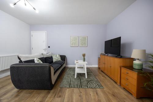 a living room with a couch and a tv at Stunning 3BR, Free Parking, near Town Center, Long term discoun in Reading