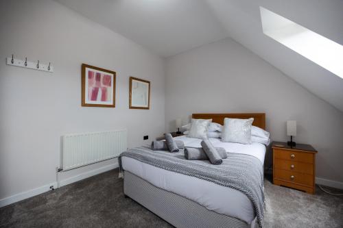 a bedroom with a large white bed with pillows at Stunning 3BR, Free Parking, near Town Center, Long term discoun in Reading