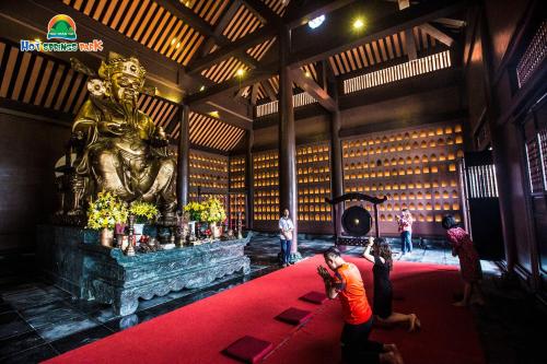 a group of people standing around a red carpet in a building with a statue at Ebisu Onsen Resort in Ba Na
