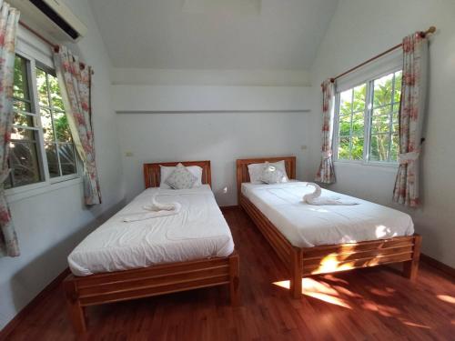 Postel nebo postele na pokoji v ubytování Suriyan Villa Erawan Kanchanaburi สุริยัน วิลล่า เอราวัณ กาญจนบุรี