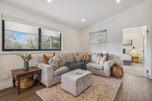 a living room with a couch and a table at Nowhere Cottage in Crackenback