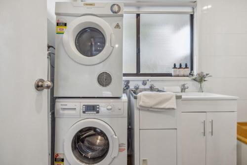 a bathroom with a washing machine and a sink at Nowhere Cottage in Crackenback