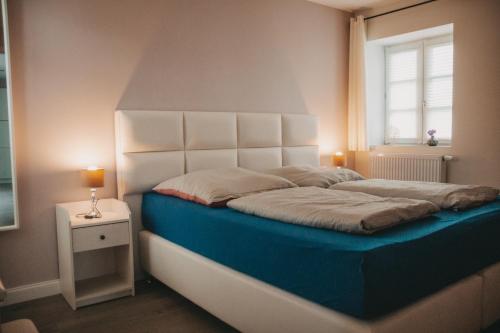 a bedroom with a bed with a white headboard and a window at Kavaliershaus Henriettenhof in Grömitz