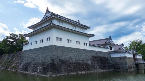 a large white building on top of a brick wall at Toyoko Inn Shizuoka eki Kita guchi in Shizuoka